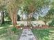 Inviting backyard with a stone path, lush trees, and comfortable seating areas at 5852 Medinah Way, Orlando, FL 32819