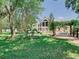 Expansive backyard with lush greenery, a pergola, and a beautiful two-story building at 5852 Medinah Way, Orlando, FL 32819