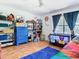 Bright bedroom showcasing wooden floors, shelving, and play items creating a fun and organized space at 5852 Medinah Way, Orlando, FL 32819