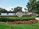 Welcome to Bay Hill: a beautifully landscaped entrance sign with lush greenery and manicured flower beds at 5852 Medinah Way, Orlando, FL 32819
