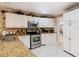 Traditional kitchen features white cabinets, stainless steel oven, and granite countertops at 5852 Medinah Way, Orlando, FL 32819