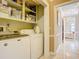 Functional laundry area with washer and dryer, storage shelves, and easy access to additional rooms at 5852 Medinah Way, Orlando, FL 32819