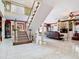 Bright living room with open staircase, tile floors, and a large leather couch at 5852 Medinah Way, Orlando, FL 32819