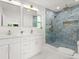 Bathroom with double sink vanity, gold fixtures and tile shower with accent niche at 625 N Central Ave, Oviedo, FL 32765