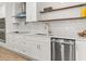 Modern kitchen with white cabinets, stainless steel appliances, and stylish floating shelves at 625 N Central Ave, Oviedo, FL 32765
