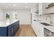 Beautiful kitchen with white cabinetry, a blue island, and stainless steel appliances at 625 N Central Ave, Oviedo, FL 32765