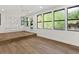 Bright living room with wood floors, white walls, and large windows overlooking the backyard at 625 N Central Ave, Oviedo, FL 32765