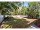 Lush backyard featuring mature trees, a well-maintained lawn, and privacy fence, creating a private outdoor oasis at 657 Overspin Dr, Winter Park, FL 32789