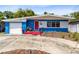 Charming single-story home with a bright blue and white exterior, red door, and well-maintained landscaping at 657 Overspin Dr, Winter Park, FL 32789