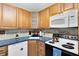 Well-maintained kitchen with wood cabinetry, a white microwave, and modern appliances at 657 Overspin Dr, Winter Park, FL 32789