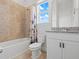 Comfortable bathroom showcasing a shower-tub, a toilet, and a vanity, all illuminated by natural light at 6875 Bridgman St, Orlando, FL 32827