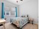Cozy bedroom featuring wood-look floors, a ceiling fan, bright windows, and a stylishly decorated bed at 6875 Bridgman St, Orlando, FL 32827