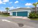 Exterior shot of the detached two-car garage with two palm trees and green shrubbery at 6875 Bridgman St, Orlando, FL 32827