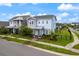 Charming two-story home featuring a landscaped yard, complemented by blue sky and manicured lawn at 6875 Bridgman St, Orlando, FL 32827