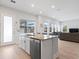 Open-concept kitchen with a large center island, stainless steel dishwasher, and seamless flow into the living area at 6875 Bridgman St, Orlando, FL 32827