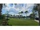 A zero entry pool is surrounded by palm trees, blue skies with clouds, and a manicured lawn at 6875 Bridgman St, Orlando, FL 32827