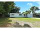 Single-story home with a lush lawn and mature trees creating a serene landscape at 707 N Solandra Dr, Orlando, FL 32807