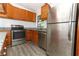 Updated kitchen featuring stainless steel appliances, wood cabinets, and granite countertops at 707 N Solandra Dr, Orlando, FL 32807
