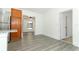 Open living room with grey wood floors leading into dining area and hallway at 707 N Solandra Dr, Orlando, FL 32807