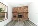 Living room with a stone fireplace, a large window and light grey wood-look flooring at 707 N Solandra Dr, Orlando, FL 32807