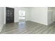 Bright, freshly painted living room featuring durable vinyl floors, a new front door, and a view from the large window at 707 N Solandra Dr, Orlando, FL 32807