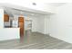 Open-concept living space showing off white walls, gray floors, and a view of the adjacent kitchen area and stainless fridge at 707 N Solandra Dr, Orlando, FL 32807