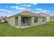 A sprawling backyard features a covered patio with outdoor dining, perfect for entertaining guests at 746 Mocking Jay Ln, St Cloud, FL 34771