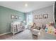 Charming Bedroom featuring a crib, decorative animal prints, and a cozy rocking chair for a soothing environment at 746 Mocking Jay Ln, St Cloud, FL 34771