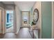 Welcoming entryway with wood flooring, a decorative mirror, and view into a bedroom at 746 Mocking Jay Ln, St Cloud, FL 34771