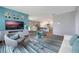 Cozy living room featuring modern decor, an entertainment center, and an open layout connected to the dining area at 746 Mocking Jay Ln, St Cloud, FL 34771