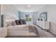 Bright main bedroom featuring a large window, white furniture, and chic decor at 746 Mocking Jay Ln, St Cloud, FL 34771
