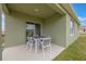 Covered outdoor patio with modern outdoor dining set, perfect for entertaining and relaxation at 746 Mocking Jay Ln, St Cloud, FL 34771