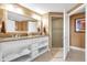 Bright bathroom featuring a double sink vanity, granite countertops, and a glass-enclosed shower at 7593 Gathering Dr # 502, Reunion, FL 34747