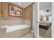 This bathroom showcases a soaking tub, tile surround, and elegant fixtures for a relaxing experience at 7593 Gathering Dr # 502, Reunion, FL 34747