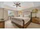 Comfortable bedroom featuring a tufted headboard, ceiling fan, and view from the window at 7593 Gathering Dr # 502, Reunion, FL 34747