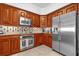 This kitchen has stainless steel appliances, wooden cabinets, tile backsplash, and stone countertops at 7593 Gathering Dr # 502, Reunion, FL 34747