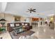 Spacious living room with a plush leather sofa, a ceiling fan, and access to the kitchen area at 7593 Gathering Dr # 502, Reunion, FL 34747