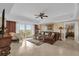Spacious living room with a ceiling fan, outdoor balcony, large picture window, and comfortable lounge furniture at 7593 Gathering Dr # 502, Reunion, FL 34747