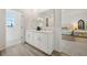 Bright bathroom with double vanity and framed mirrors, and a view into the bedroom at 776 Mocking Jay Ln, St Cloud, FL 34771