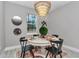 Charming dining room features a round table, seating for four, modern lighting, and a view of the outdoors at 8202 Sw 123Rd Ter, Dunnellon, FL 34432