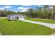 Well-maintained home featuring a long driveway, two-car garage and green lawn at 8202 Sw 123Rd Ter, Dunnellon, FL 34432