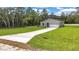 Well-maintained home featuring a long driveway, two-car garage and green lawn at 8202 Sw 123Rd Ter, Dunnellon, FL 34432