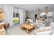 Open-concept living room with a comfortable seating area, backyard views, and a modern kitchen in the background at 8202 Sw 123Rd Ter, Dunnellon, FL 34432