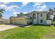 Inviting two story home featuring an attached three car garage and a well manicured lawn at 9532 Water Fern Cir, Clermont, FL 34711