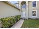 Charming front door entrance with beautiful greenery and a well-maintained walkway at 9532 Water Fern Cir, Clermont, FL 34711
