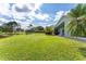 Spacious backyard with mature landscaping and serene pond views, offering a private outdoor oasis at 9563 Myrtle Creek Ln, Orlando, FL 32832