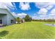Expansive backyard featuring a lush green lawn, mature trees, and tranquil pond views at 9563 Myrtle Creek Ln, Orlando, FL 32832