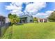 Expansive backyard with lush green lawn and tropical palm trees offering privacy at 9563 Myrtle Creek Ln, Orlando, FL 32832