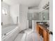Bathroom featuring double sinks, a separate tub, and glass enclosed shower at 9563 Myrtle Creek Ln, Orlando, FL 32832