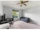 Bright bedroom featuring carpet, a ceiling fan, and a comfortable seating area at 9563 Myrtle Creek Ln, Orlando, FL 32832